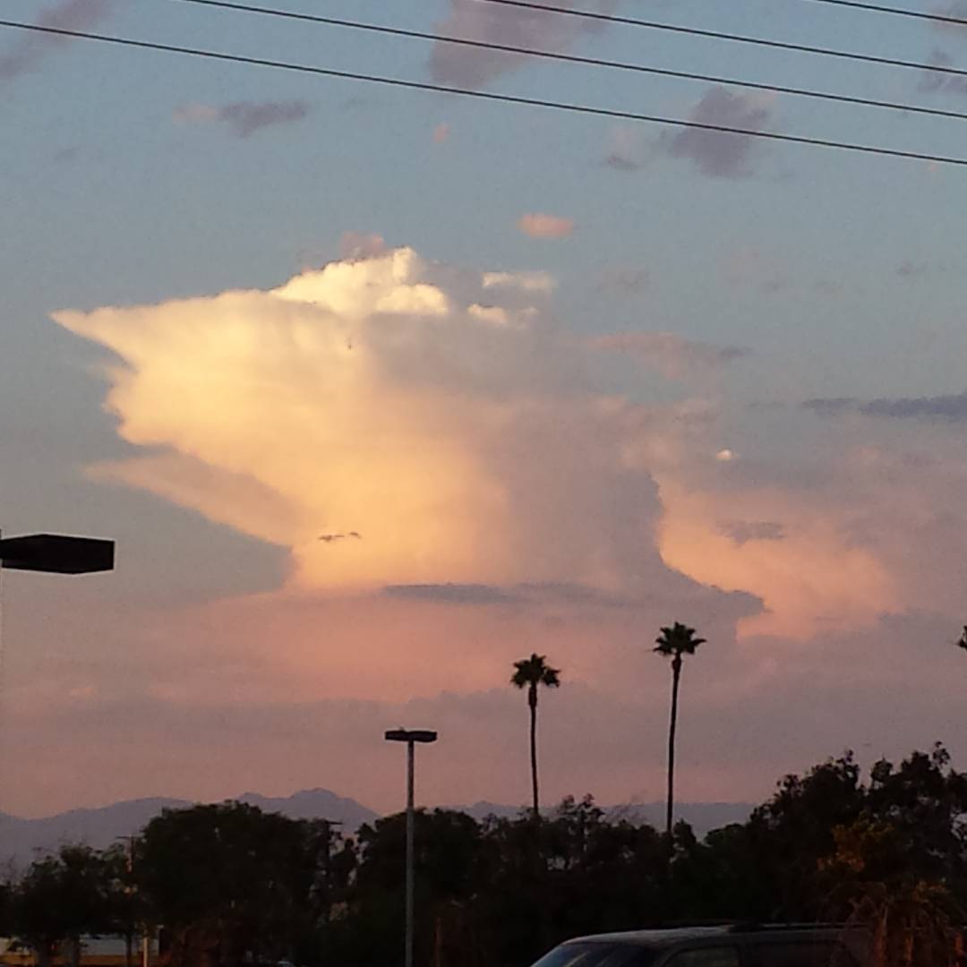 Towering thunderhead in the distance, lit up by the sunset.