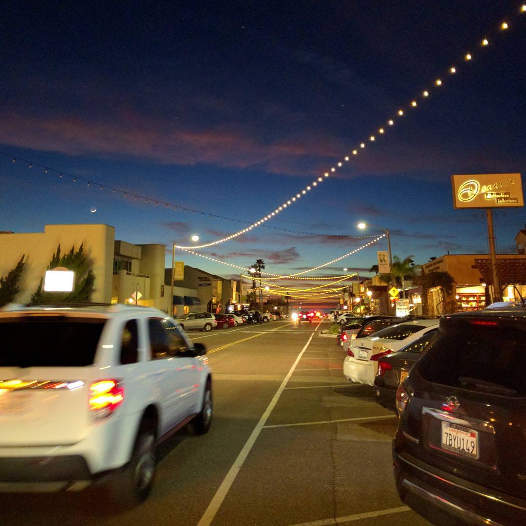 Twilight in a beach town. The ocean is just visible at the end of the road, below the orange band of sky at the horizon.

#california #redondobeach #eveningsky