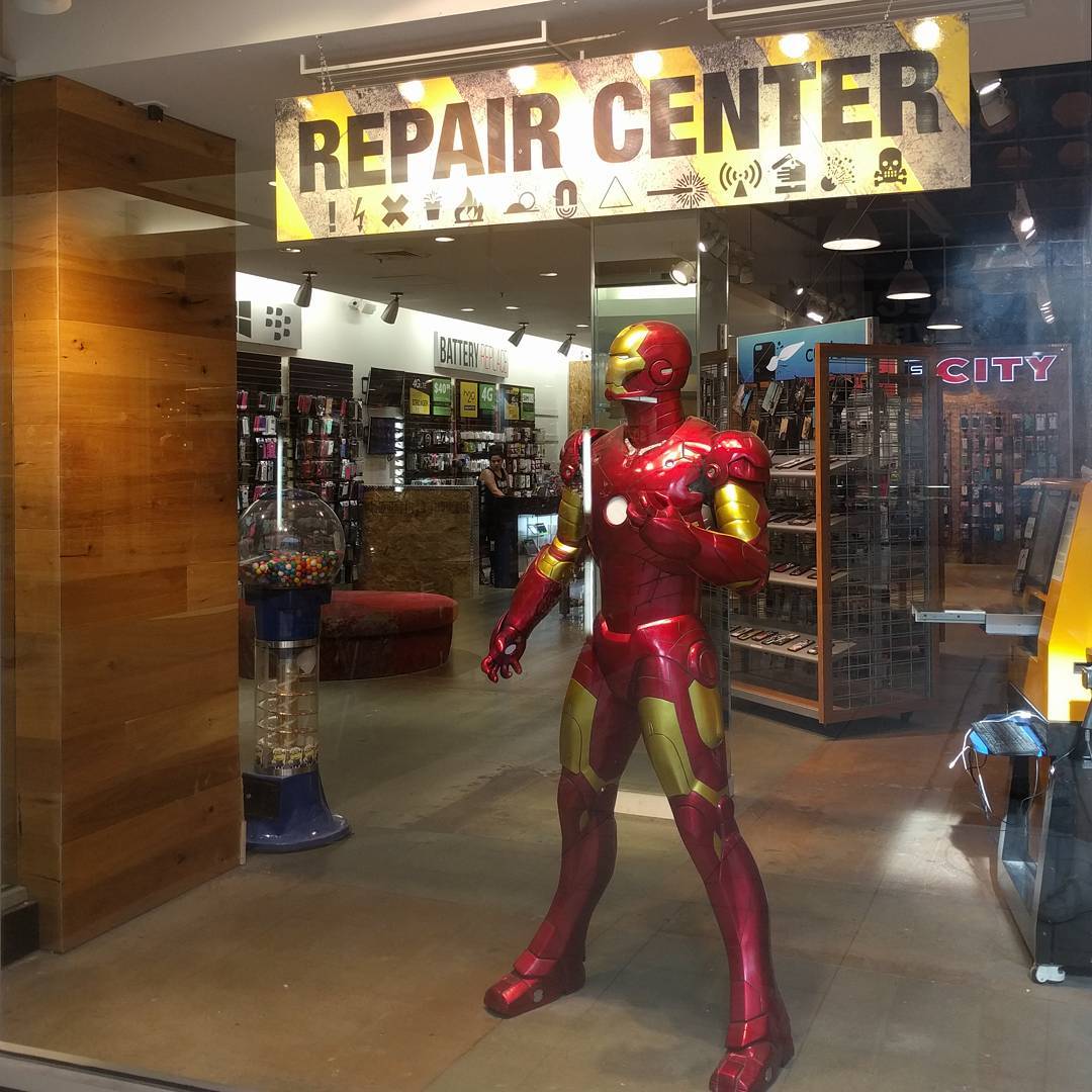 Iron Man Statue in front of a phone repair shop.