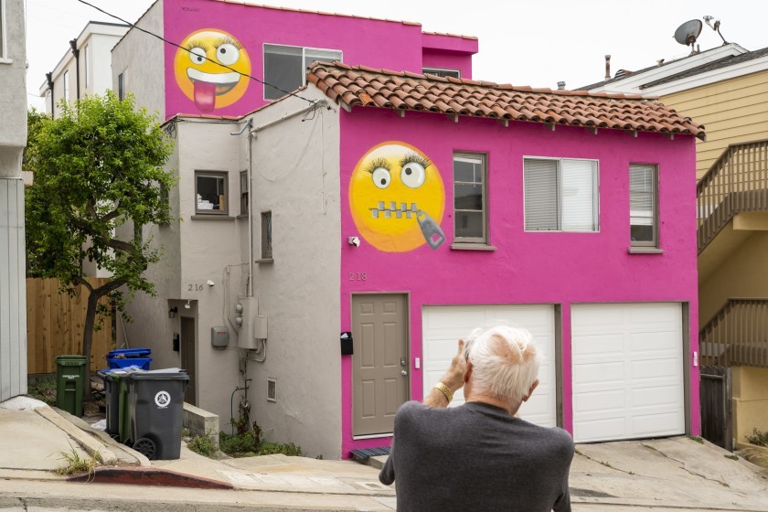 Bright pink house with screwball emoji on it.