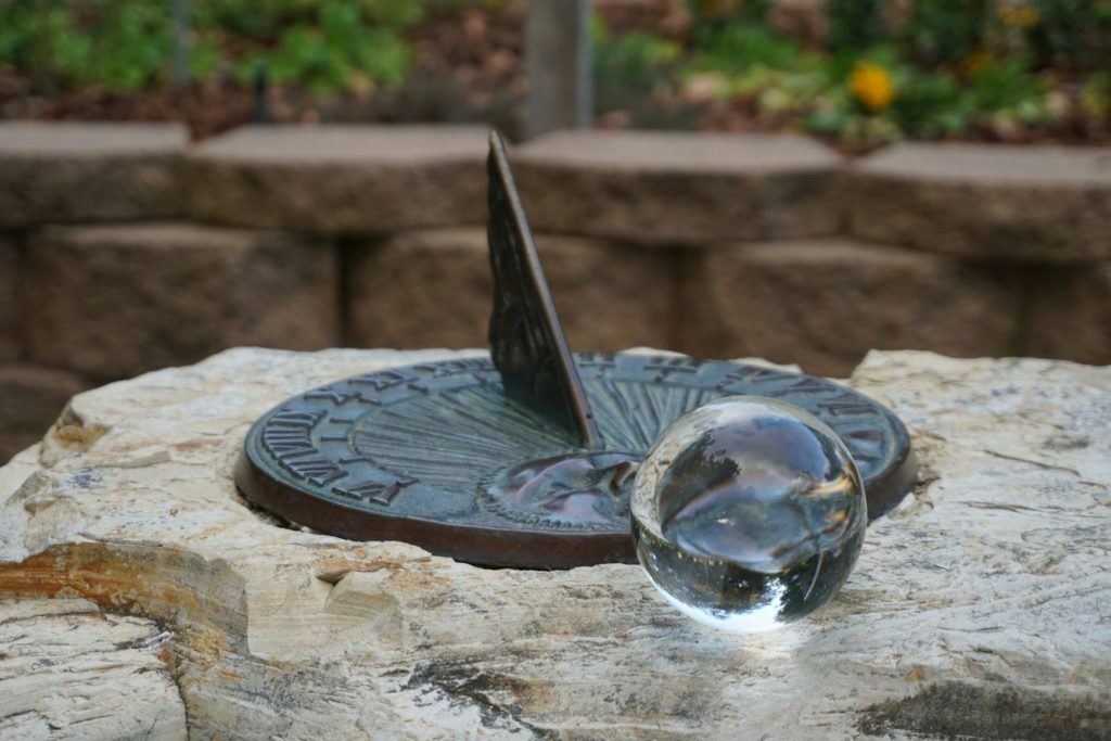 Crystal ball in front of a sundial.