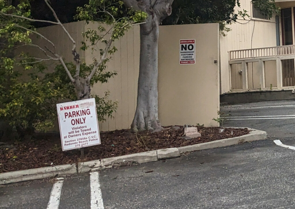 Sign at parking space: BARBER PARKING ONLY

Sign behind parking space: ABSOLUTELY NO BARBERSHOP CUSTOMER PARKING ANYWHERE. THANK YOU.